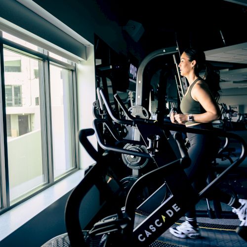 A dark alley scene with a person on a motorcycle beside a building, neon light reflections enhancing the moody atmosphere.