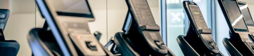 A row of treadmills in a gym with a big sign reading &ldquo;Only&rdquo; in the background.