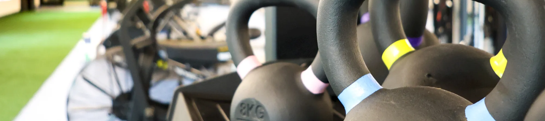 Close-up of a go-kart’s steering wheel and padded seat in an outdoor track area.